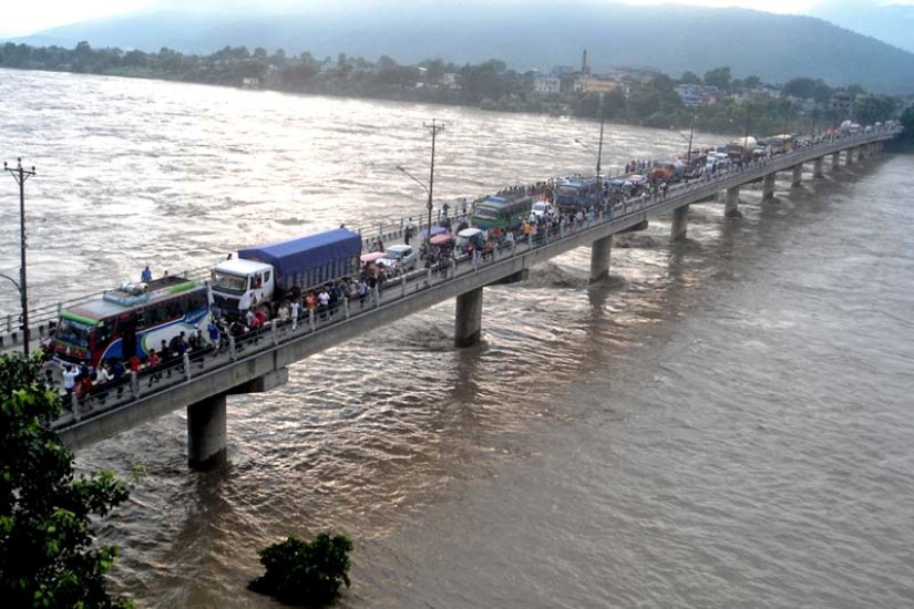 onlookers gather at the Narayani Bridge in Chitwan